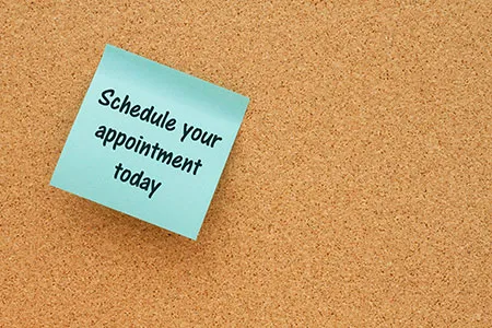 bulletin board with sticky note that says schedule your appointment today