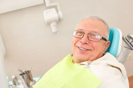 smiling older man in dental chair